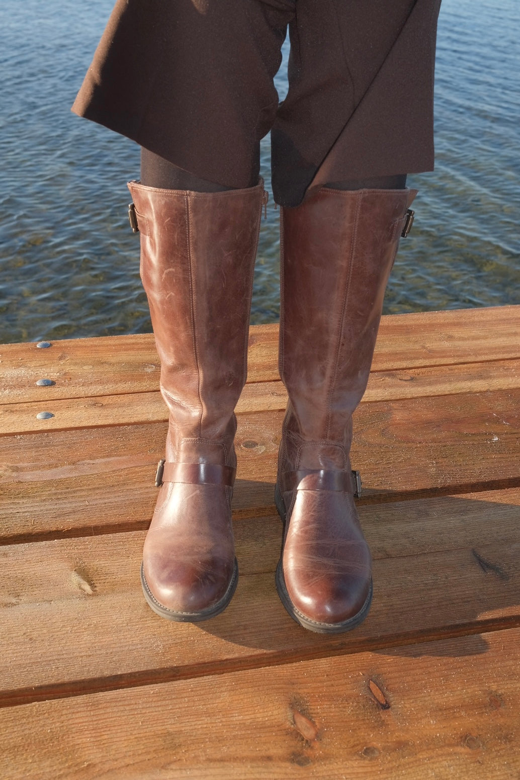 Brown leather boots with metal buckles