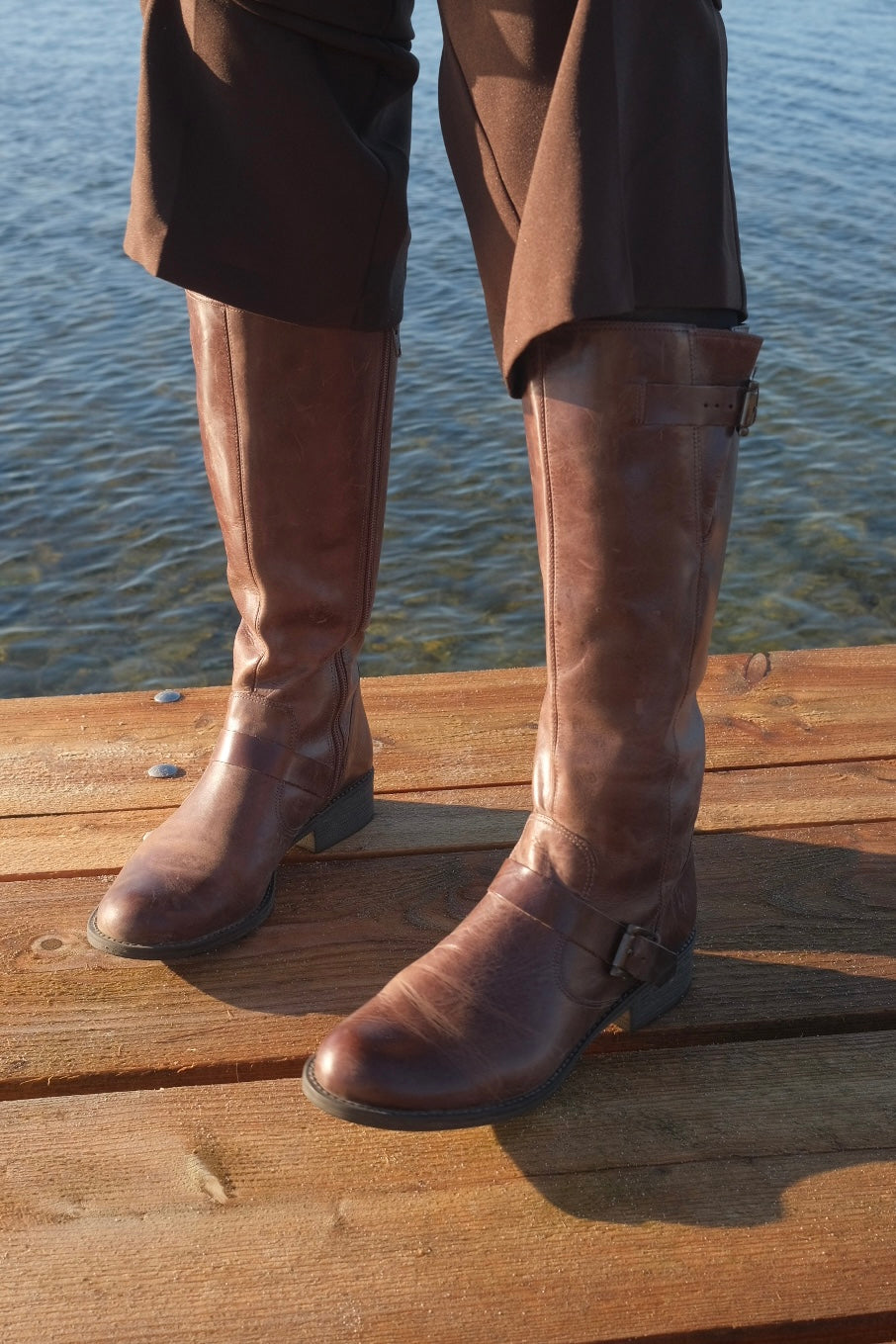 Brown leather boots with metal buckles