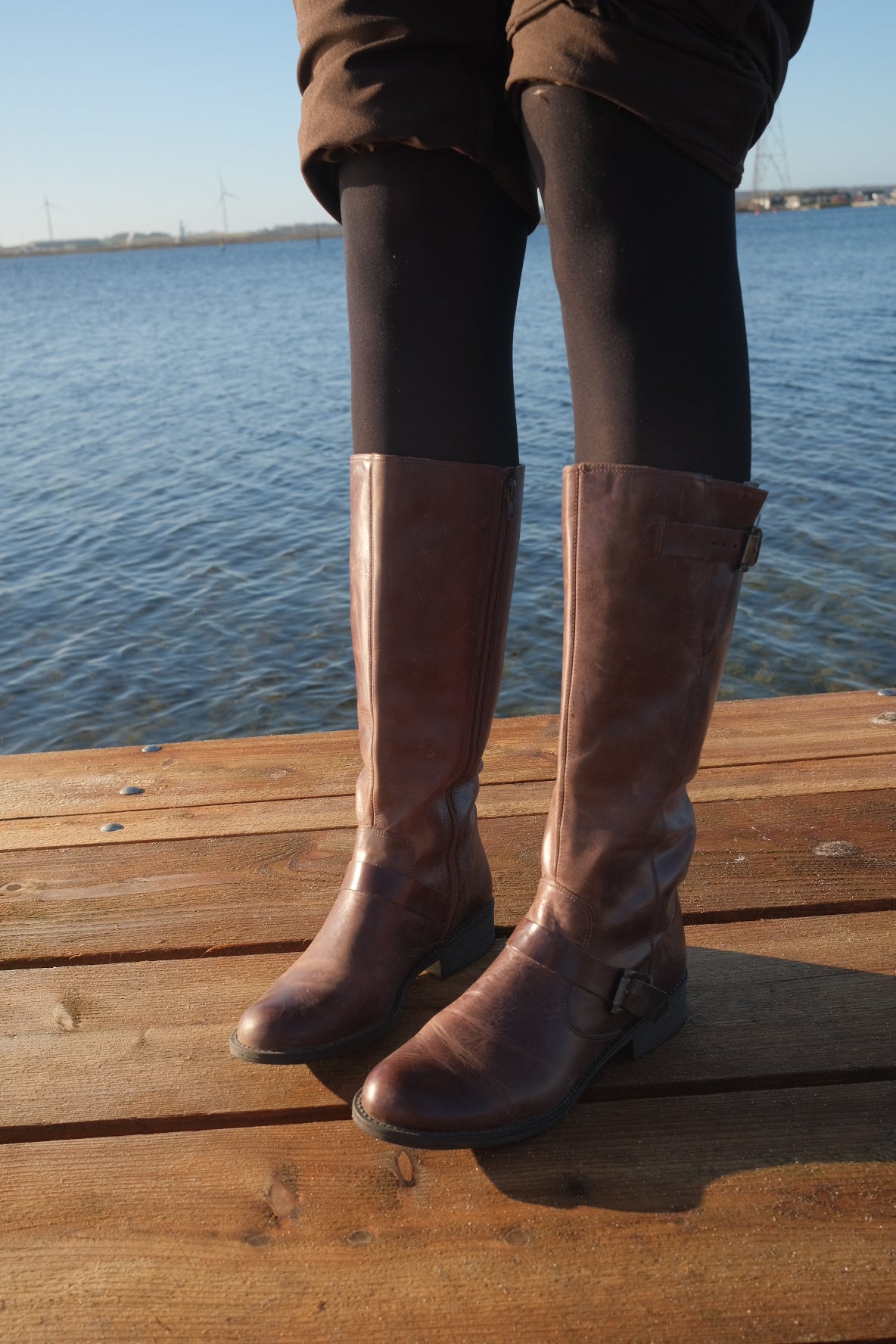 Brown leather boots with metal buckles