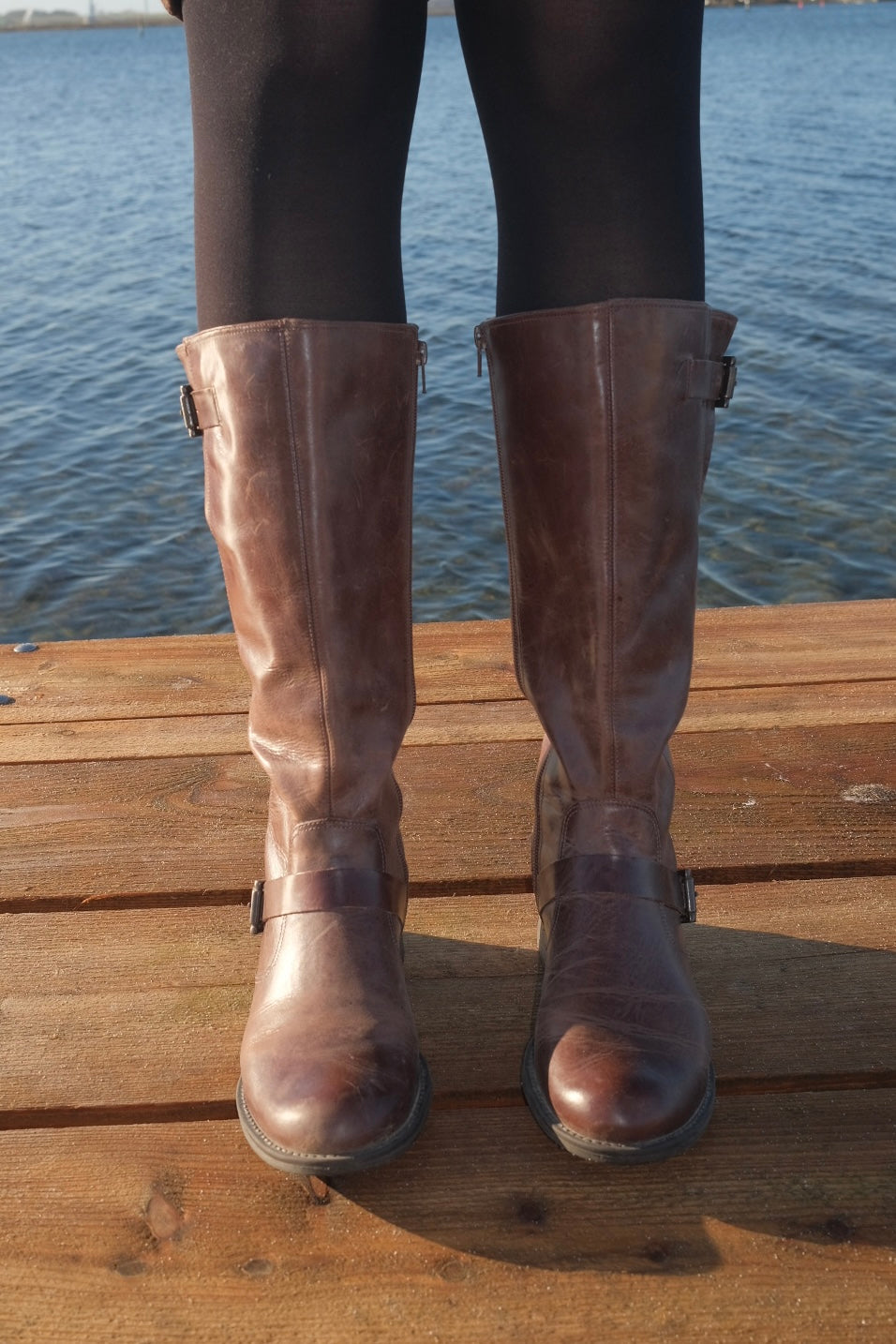 Brown leather boots with metal buckles