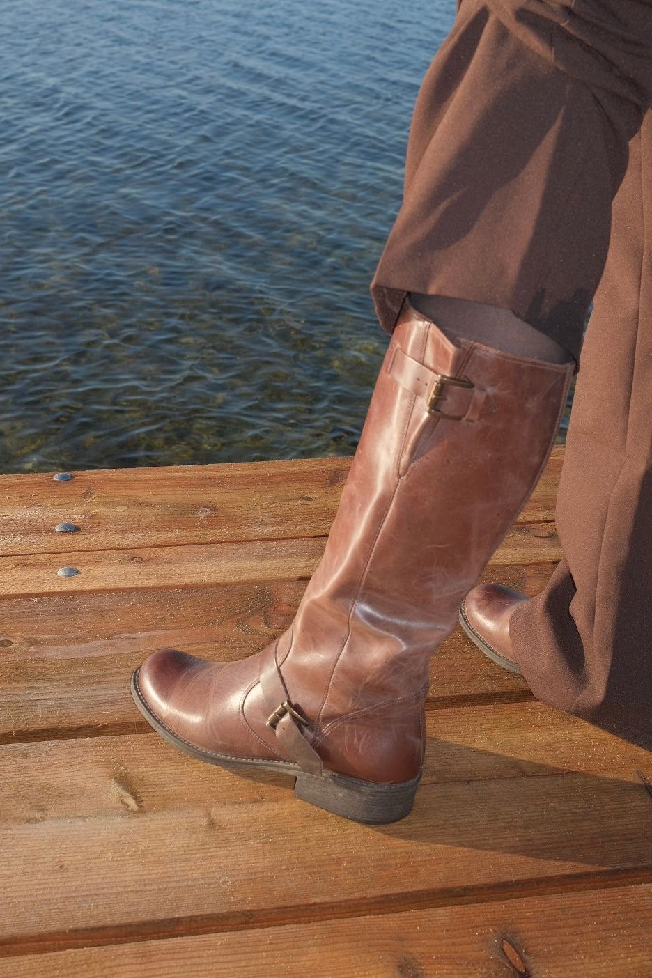 Brown leather boots with metal buckles